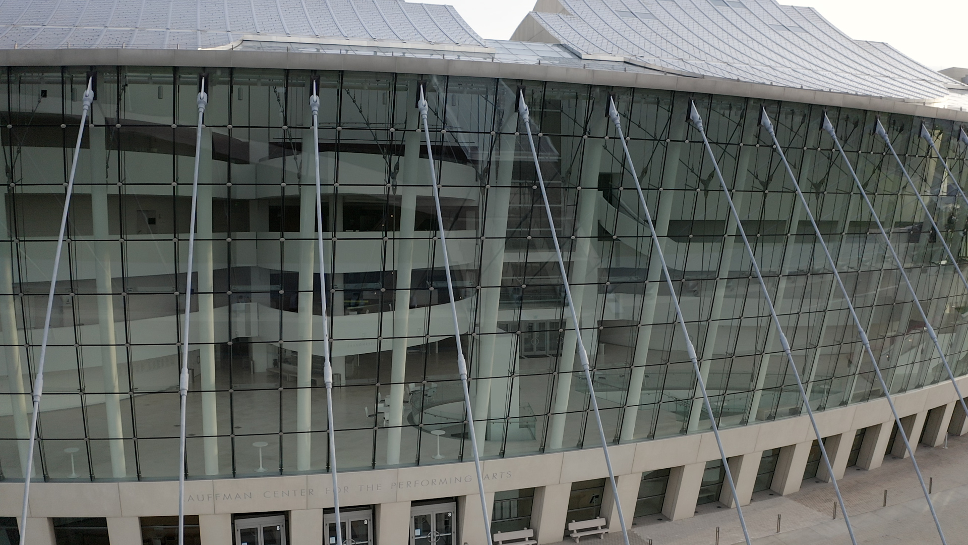 Exterior view of the Kansas City Performing Arts hub, the Kauffman Center for the Performing Arts, showcasing its glass facade and modern architectural design.